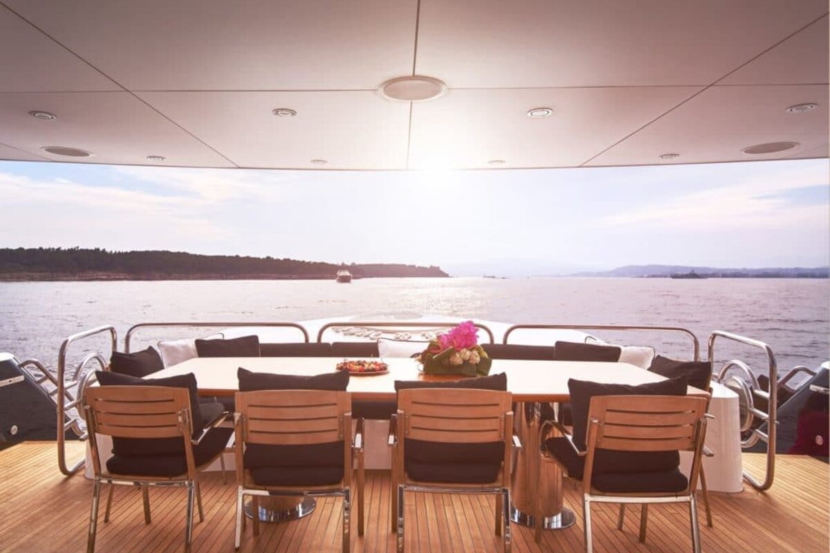A table and chairs on the deck of a boat