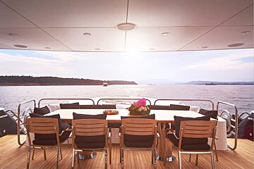 A table and chairs on the deck of a boat