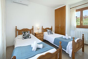 A bedroom with two beds and a bosch air conditioner