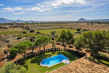 A large swimming pool in the middle of a lush green field