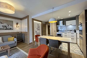 A living room with a couch and a table and chairs