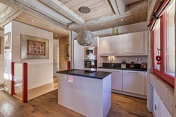 A kitchen with white cabinets and black counter tops