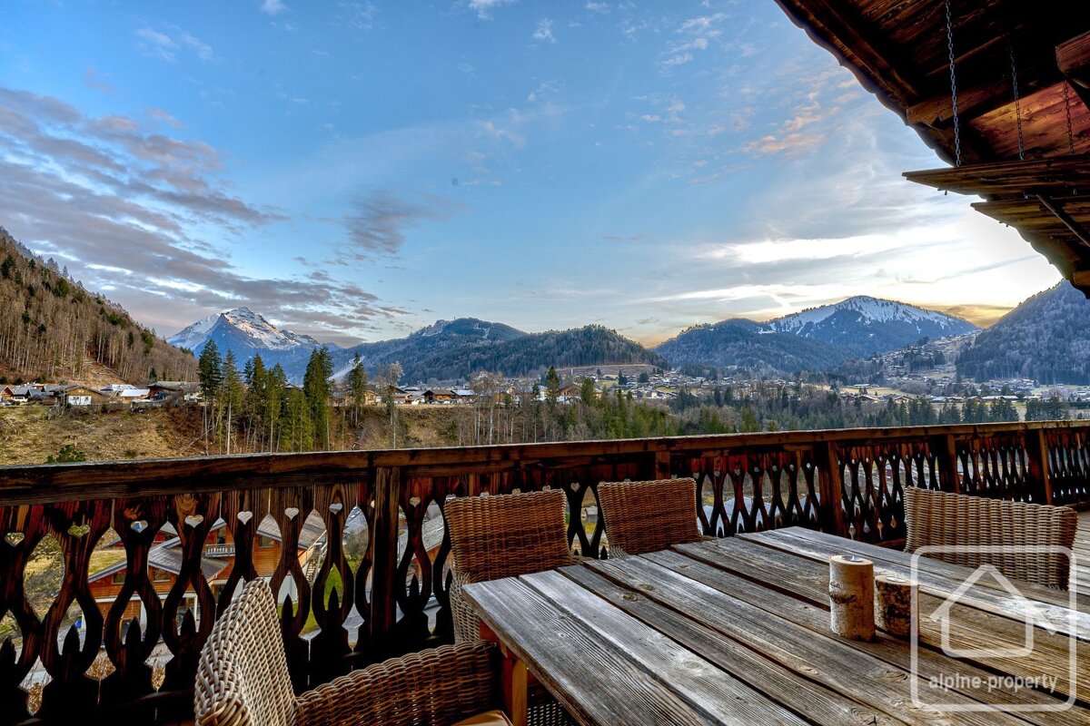 A balcony with a view of mountains and a sign that says alpine property