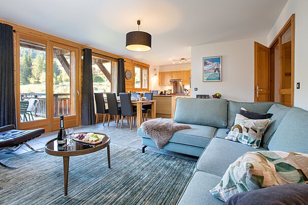 A living room with a couch and a table with a bottle of wine on it