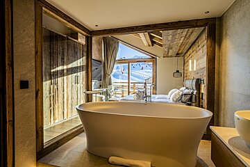 A bathroom with a bathtub and a large window