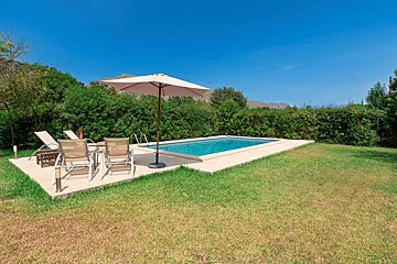 A swimming pool surrounded by chairs and an umbrella