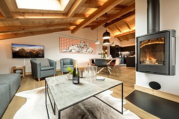A bottle of wine sits on a coffee table in a living room