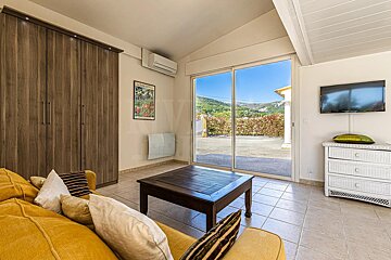 A living room with a yellow couch and a flat screen tv