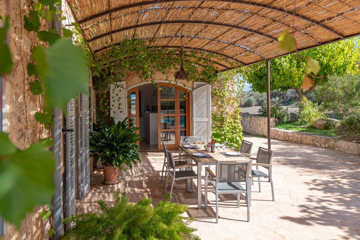 A patio with a table and chairs under a canopy