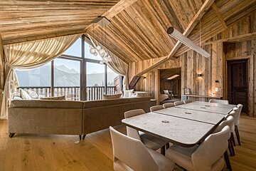 A living room with a large table and chairs