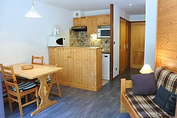 A kitchen with a table and chairs and a microwave