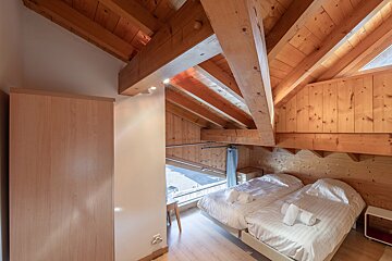 A bedroom with two beds and a sliding glass door