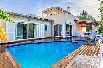 A house with a large swimming pool in front of it
