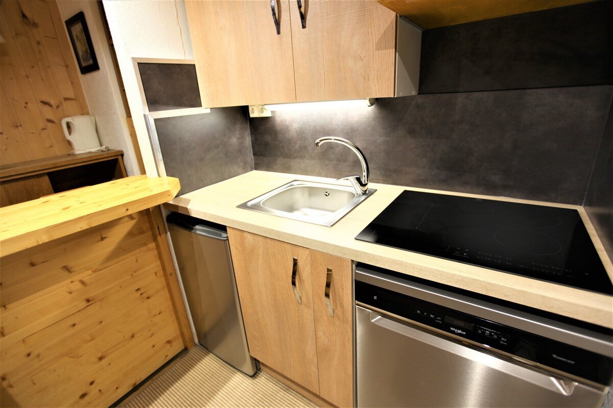 A kitchen with a stainless steel dishwasher and a stove top oven
