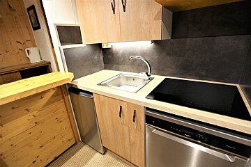 A kitchen with a stainless steel dishwasher and a stove top oven
