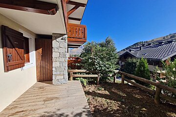 A wooden walkway leading to a balcony with mountains in the background