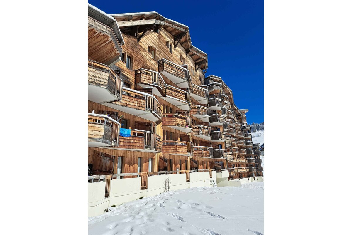 A large wooden building with a blue sky in the background