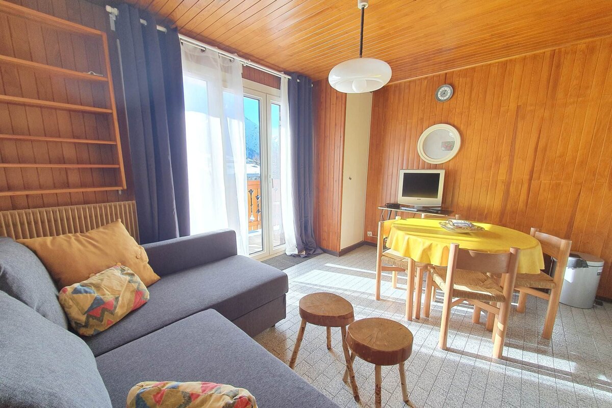A living room with a couch and a table with a yellow table cloth