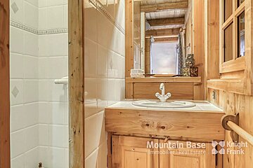 A bathroom with a wooden vanity and a sign that says mountain base