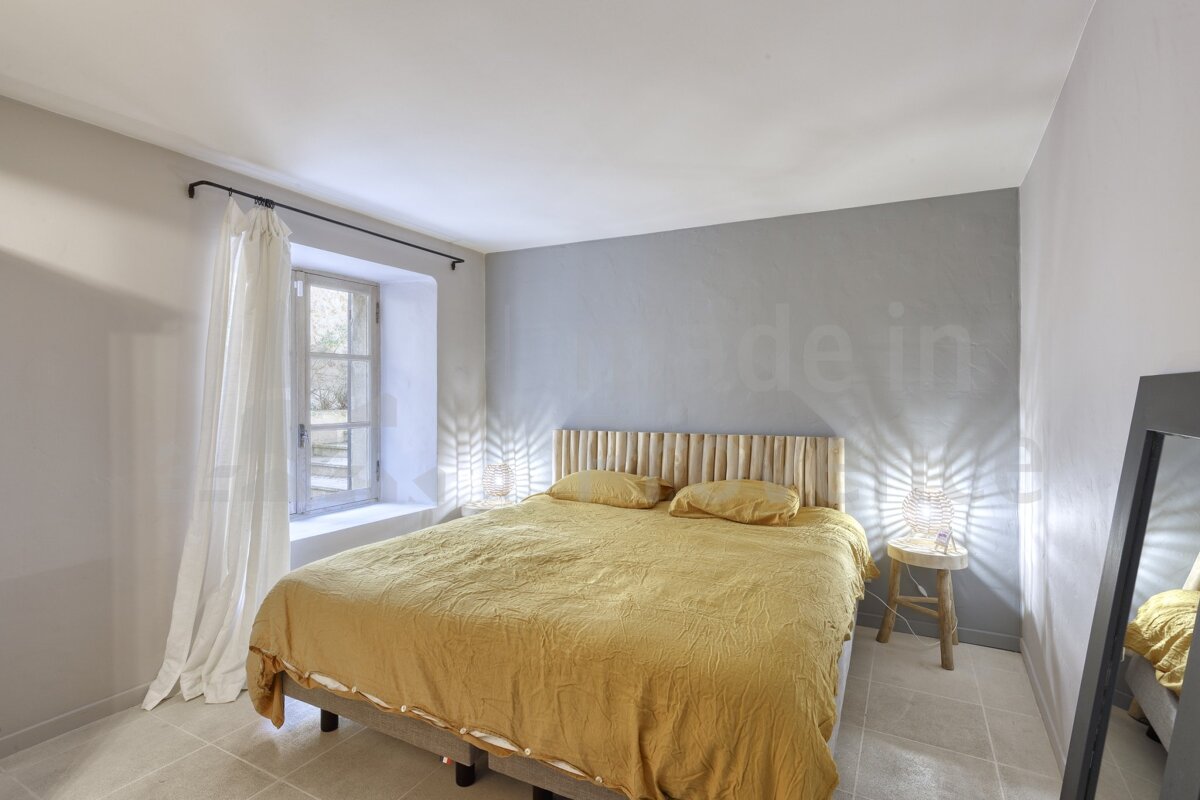 A bedroom with a bed and a mirror with the word made in on the wall