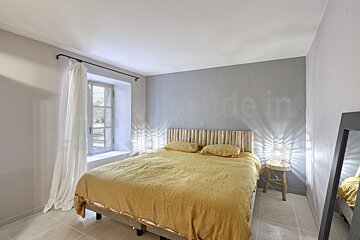 A bedroom with a bed and a mirror with the word made in on the wall