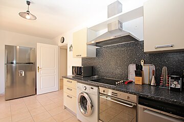 A kitchen with a washing machine and a dishwasher