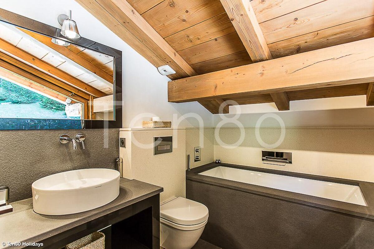 A bathroom with a sink toilet and bathtub and the number 80 on the wall