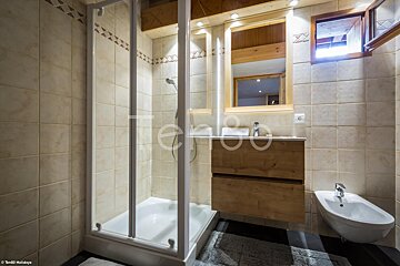 A bathroom with a shower stall and a sink with the word holidays on the bottom