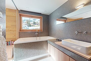 A bathroom with a tub and a sink and a window