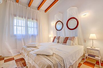 A bedroom with two beds and two mirrors on the wall