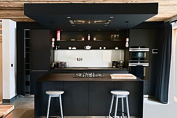 A kitchen with black cabinets and a stove top oven