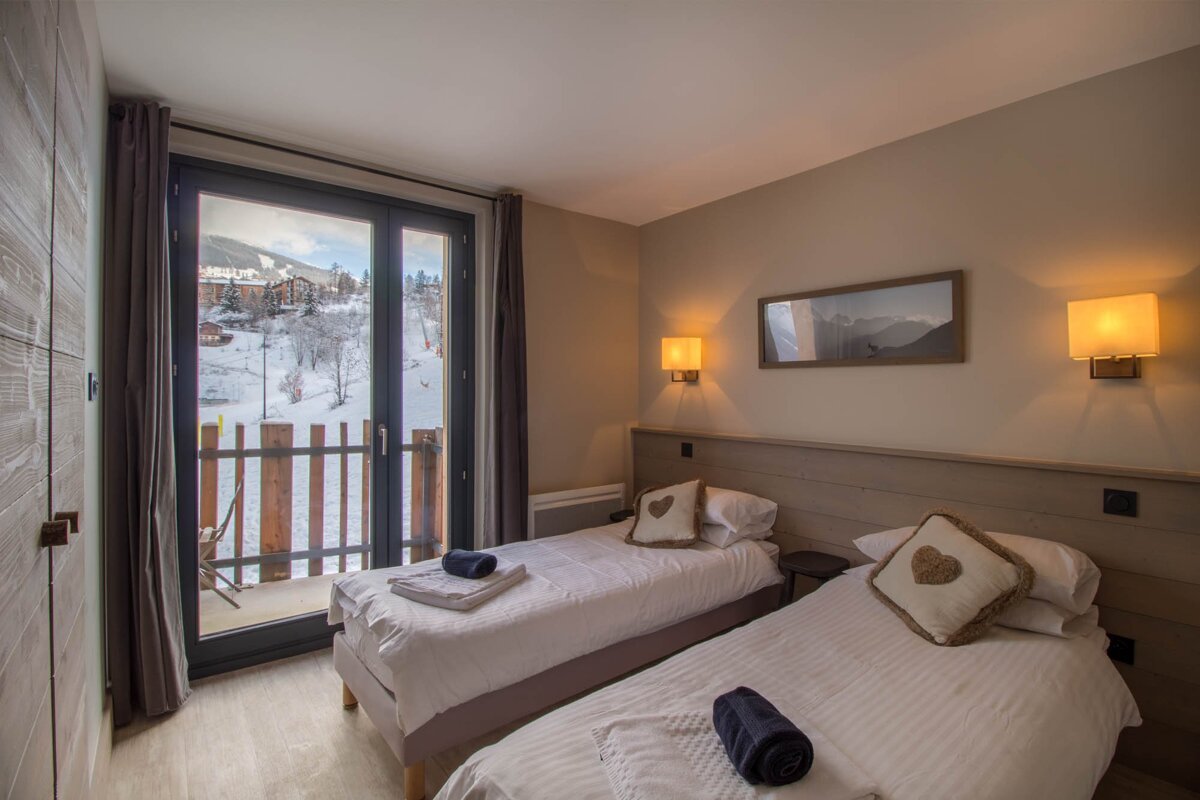 A bedroom with two beds and a picture on the wall