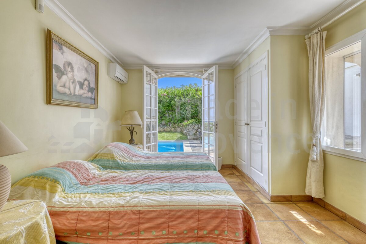 A bedroom with two beds and a picture on the wall