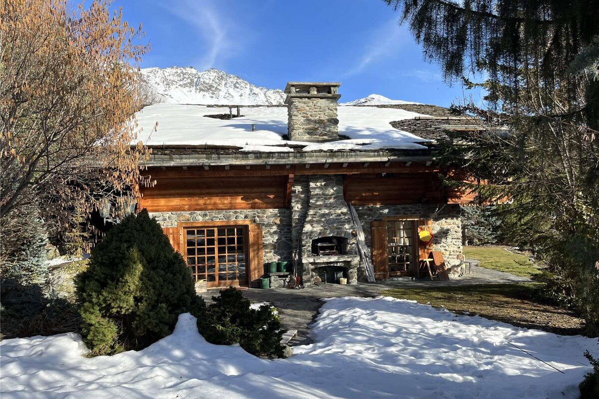 A snowy house with a chimney on the roof