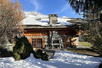 A snowy house with a chimney on the roof