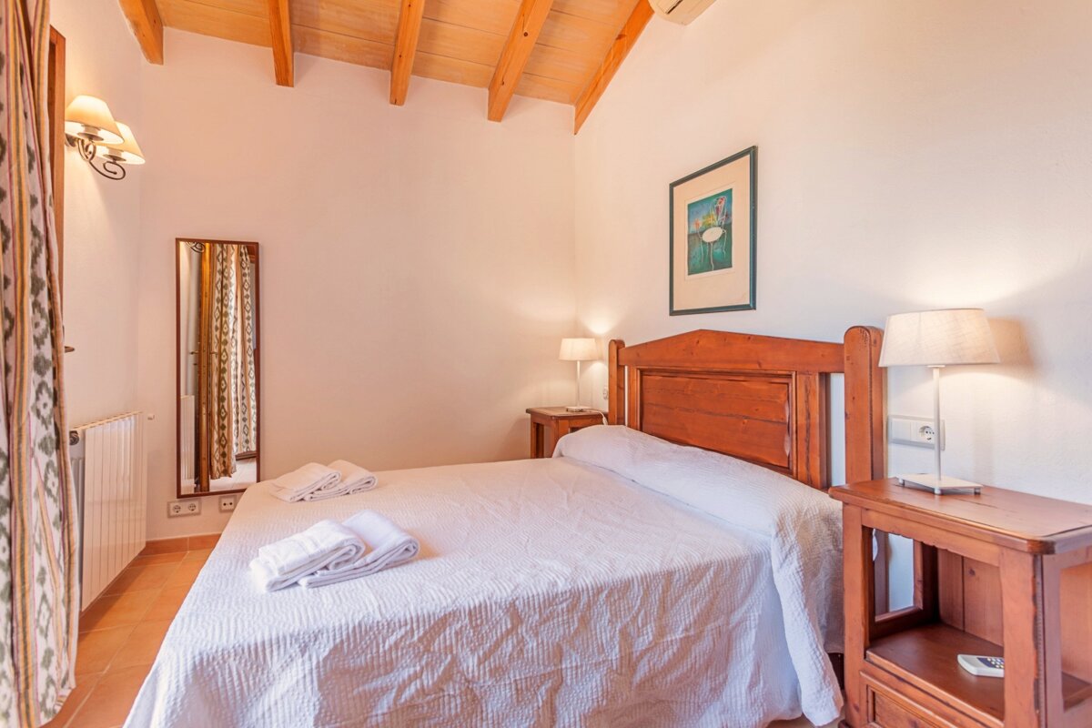 A bedroom with a bed and a picture on the wall