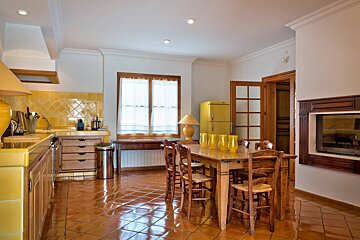 A kitchen with a table and chairs and a yellow refrigerator