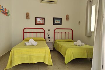 A bedroom with two beds and two pictures on the wall