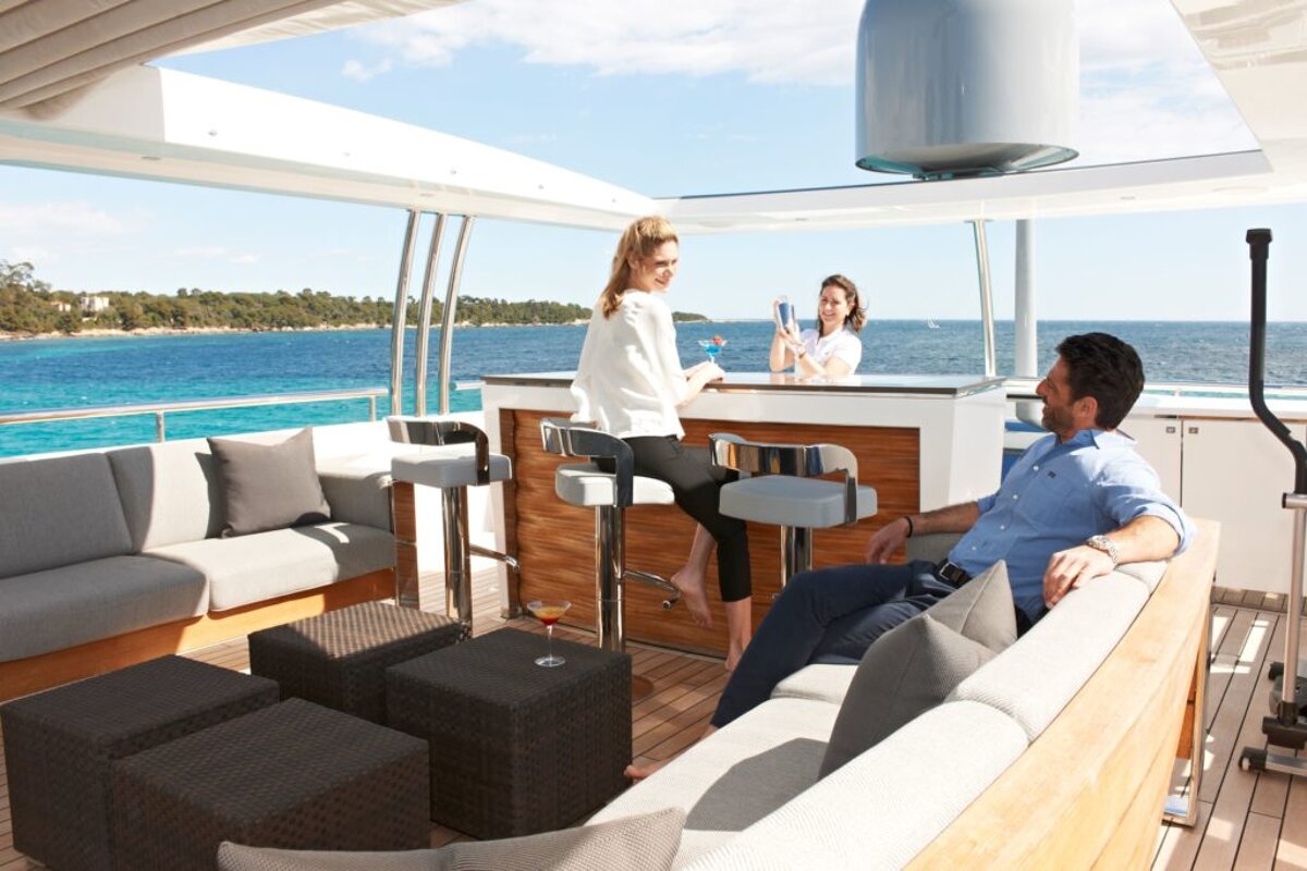 A man sits on a couch next to a woman sitting at a bar