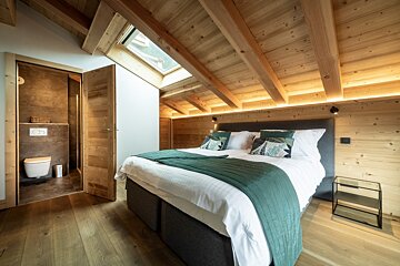 A bedroom with a large bed and a toilet