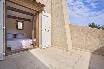 A bedroom with a sliding glass door and white shutters