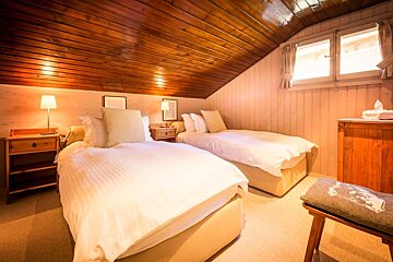 A bedroom with two beds and a dresser