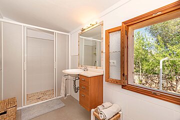 A bathroom with a sink a mirror and a window