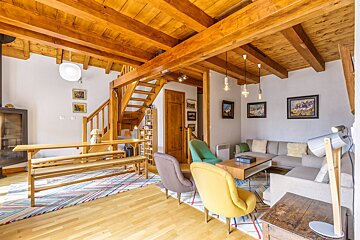 A living room with a staircase leading up to the second floor