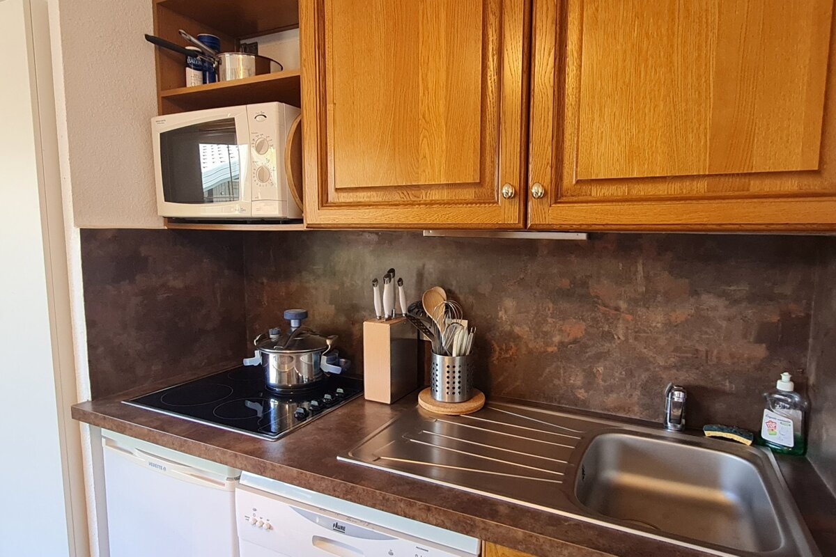 A kitchen with a stainless steel sink and a microwave