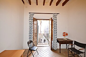 A room with a table and chairs and a fan