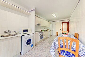 A kitchen with a washing machine and a microwave