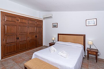 A bedroom with a large closet and a bed