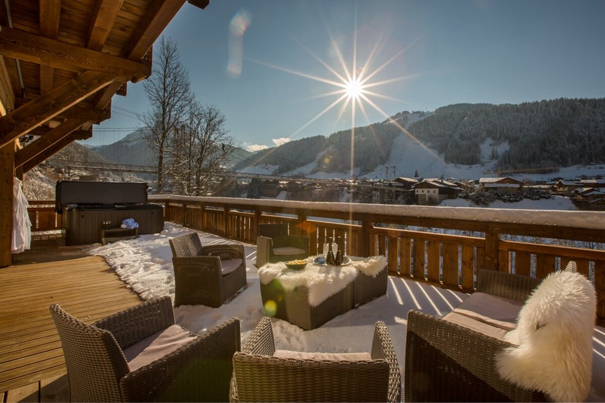 The sun shines brightly over a snow covered deck