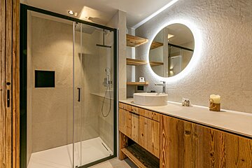 A bathroom with a round mirror and a sink